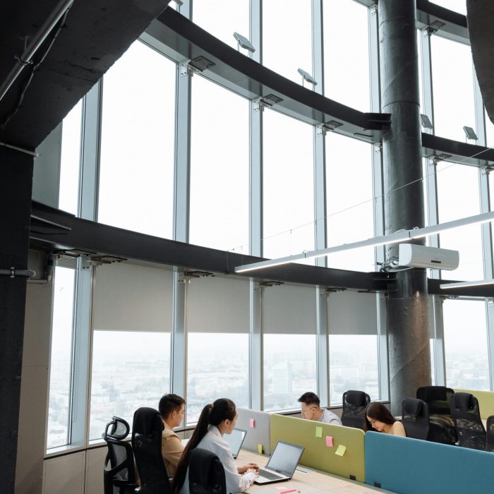 Spacious contemporary office space with employees working on laptops in a high-rise building.